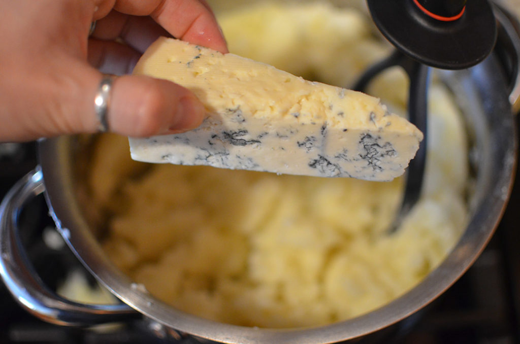 Crumble your cheese into the mash. Slowly add the rest of milk as you mash everything together.