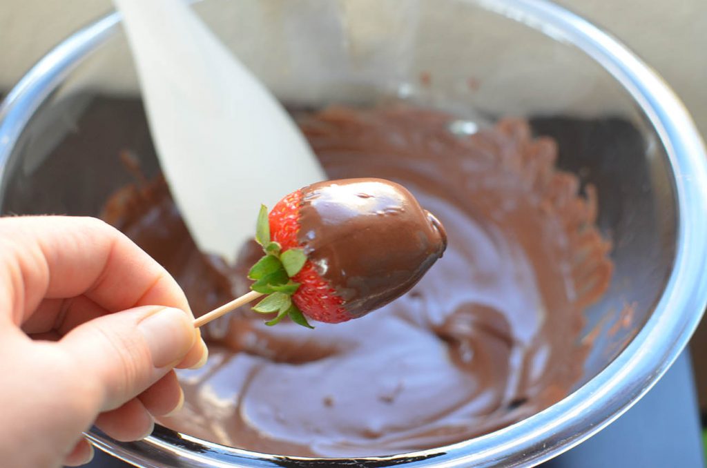 Pull out your strawberries and place a toothpick in the center. Dip and roll the strawberry in the chocolate and place on wax paper to harden. Use sprinkles if you like :)