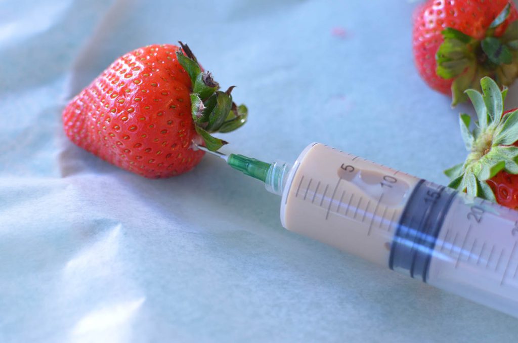 With a flavor injector slowly pump the strawberries with an alcohol of your choice. I insert the needle piece at the top of my strawberry where the green is.